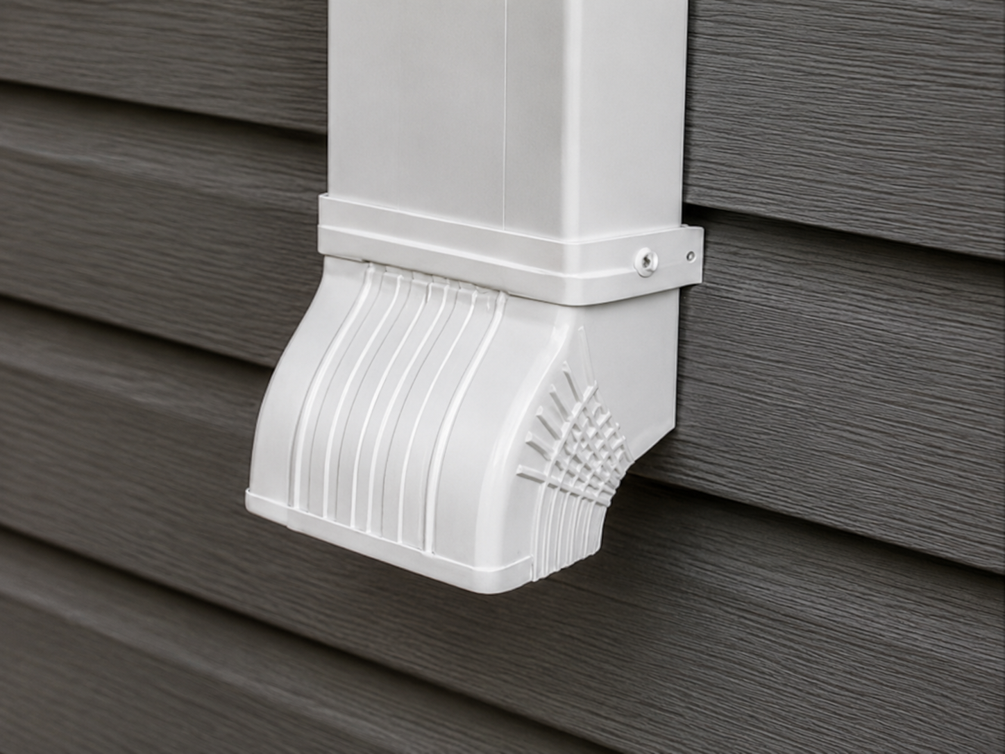White downspout connector fitted to gray siding