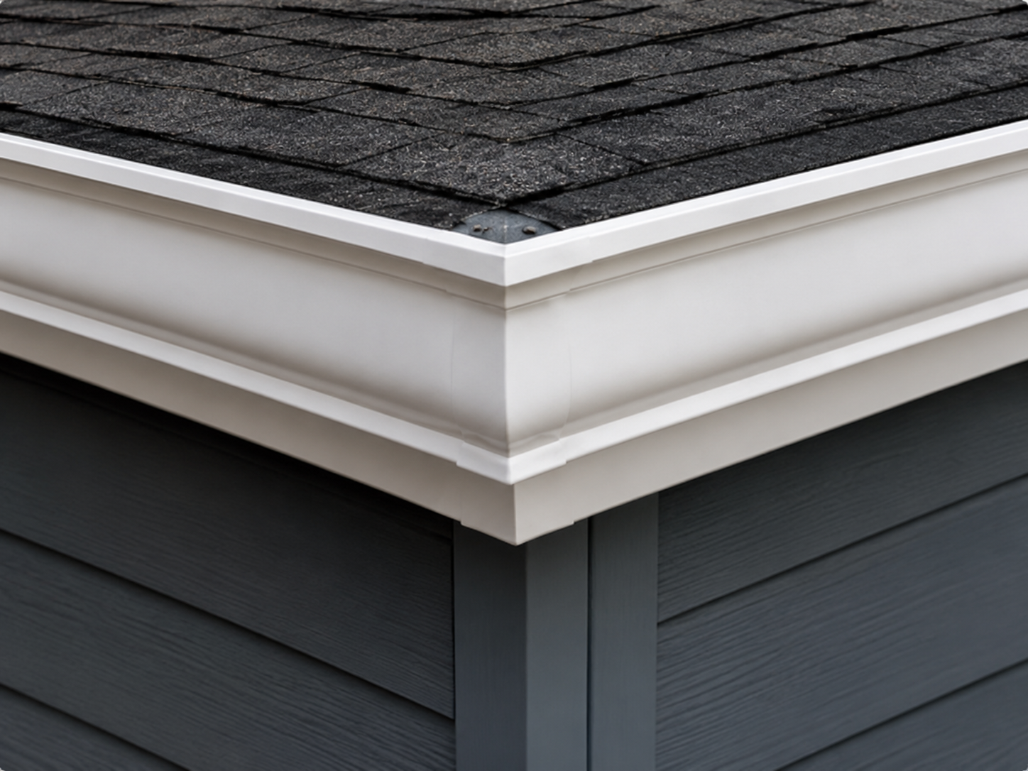 White gutter miter corner under a shingle roof